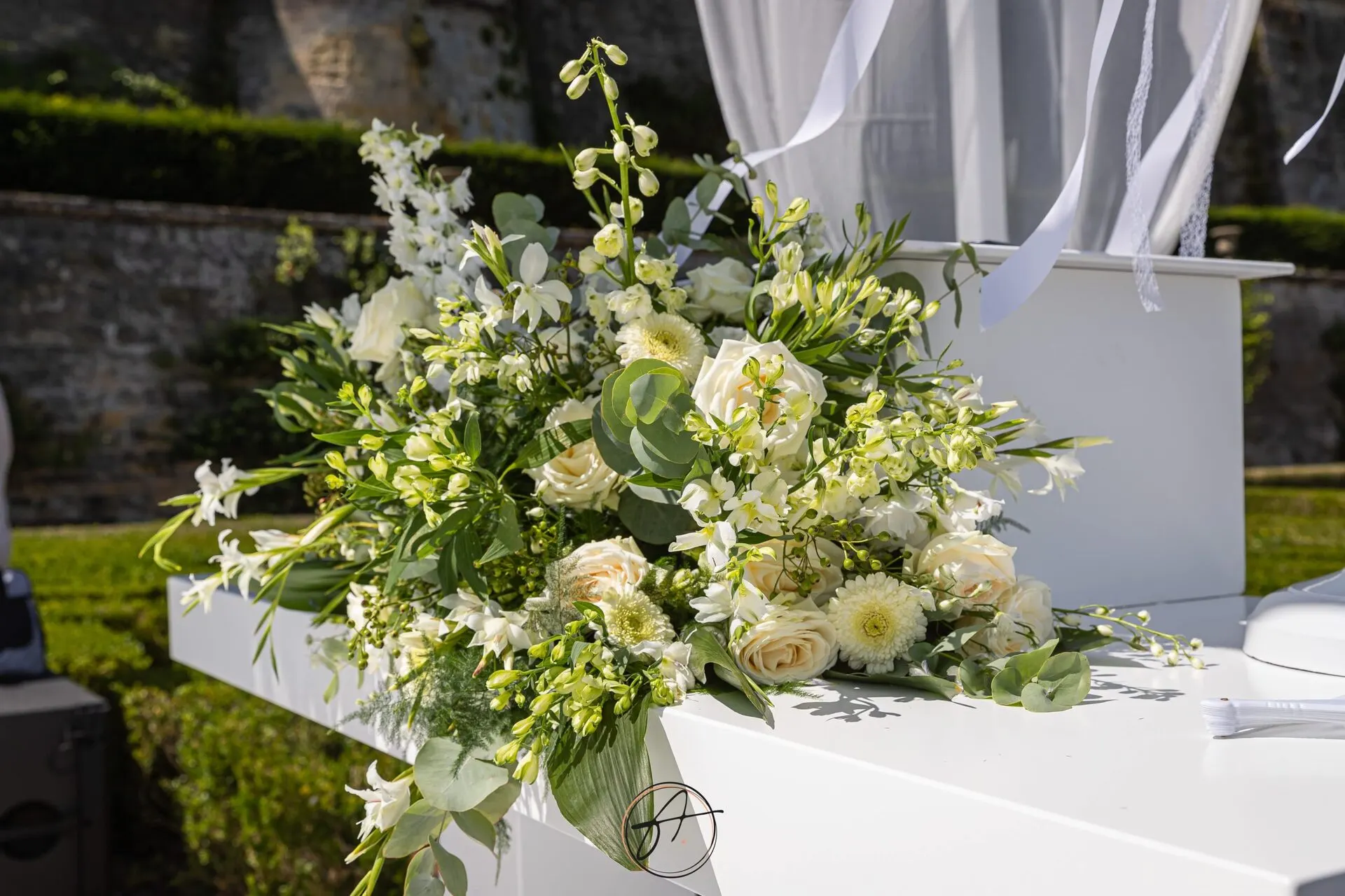 Bloemarrangementen bij het prieel van de ceremonie op Château Neercanne